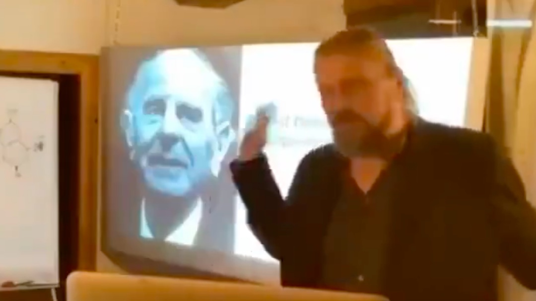 6. Dr. Noack points to an image of Sir Karl Popper on the screen.