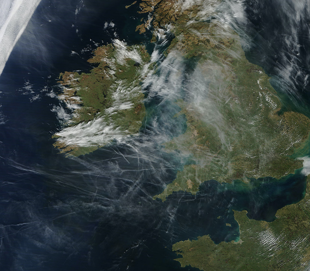 NASA satellite image of geoengineering over Britain, illustrating how a single chemtrail emission from a plane expands to many miles across (not possible from a contrail), combining to form a hazy chemical sky.